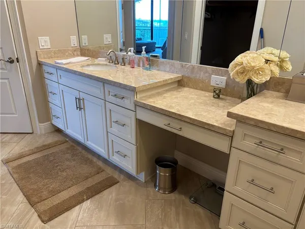 a bathroom with a granite countertop sink and a mirror