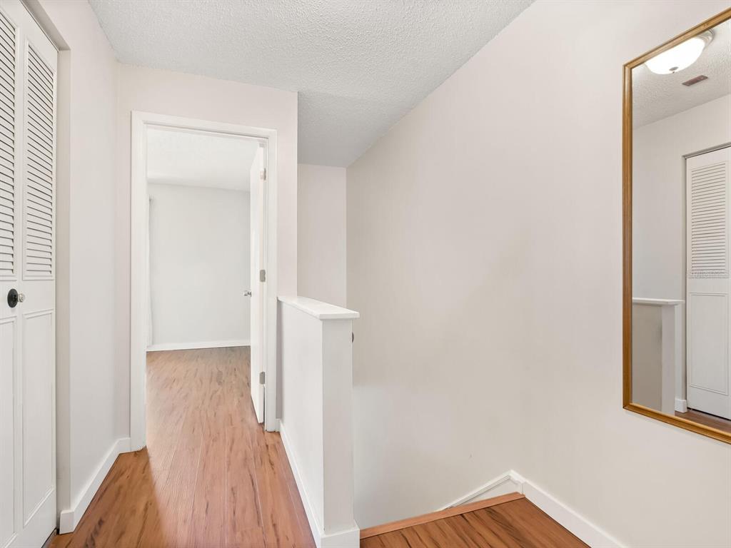 4805 Rilma Avenue, Unit 107 Sarasota, FL 34234 - Photo 17 of 42 a view of a hallway with wooden floor and staircase