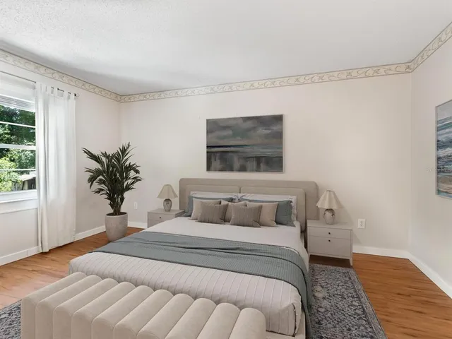 a view of an empty room with wooden floor and windows