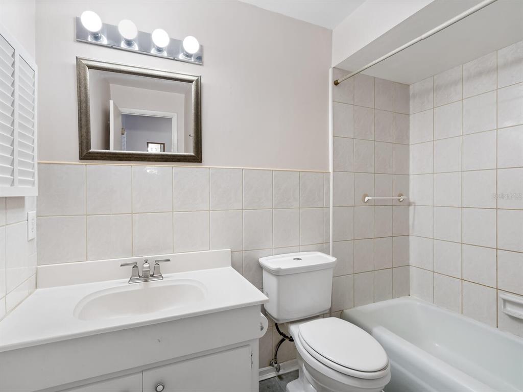 4805 Rilma Avenue, Unit 107 Sarasota, FL 34234 - Photo 21 of 42 a bathroom with a toilet a sink and mirror