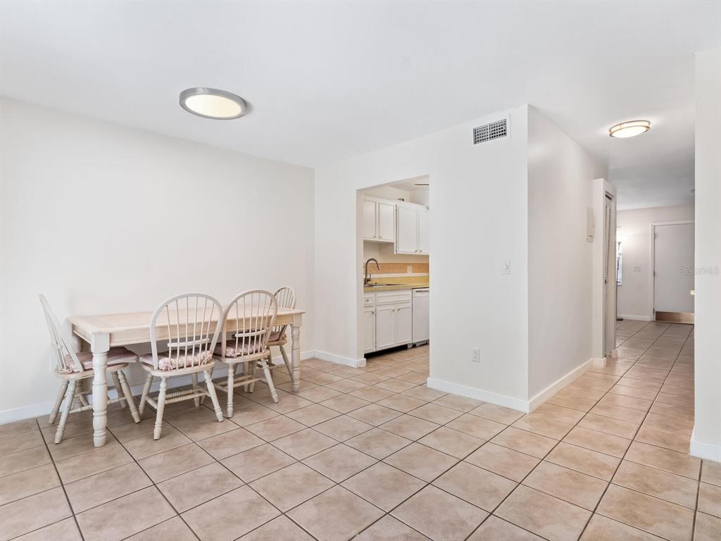 4805 Rilma Avenue, Unit 107 Sarasota, FL 34234 - Photo 10 of 42 a dining room with furniture and a chandelier