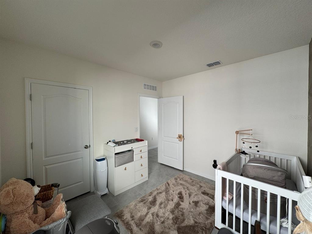 2843 Turnstone Run Harmony, FL 34773 - Photo 12 of 39 a bedroom with a bed and cabinets