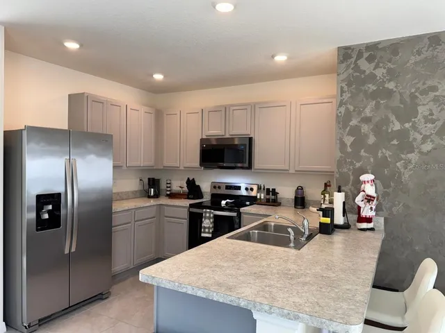 a kitchen with stainless steel appliances granite countertop a sink a stove and a refrigerator
