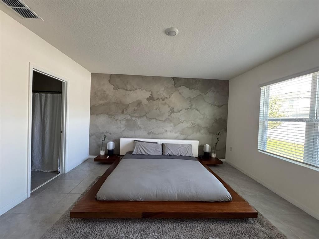 2843 Turnstone Run Harmony, FL 34773 - Photo 3 of 39 a bed sitting in a room next to a window