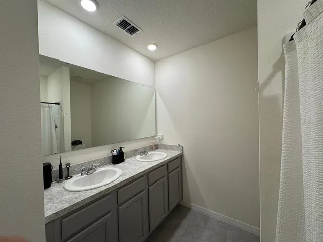a bathroom with double sink and a mirror