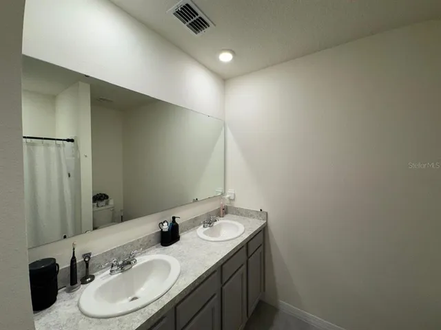a bathroom with double vanity sink and a mirror