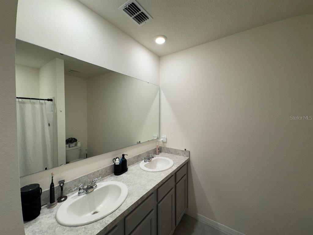 2843 Turnstone Run Harmony, FL 34773 - Photo 6 of 39 a bathroom with double vanity sink and a mirror