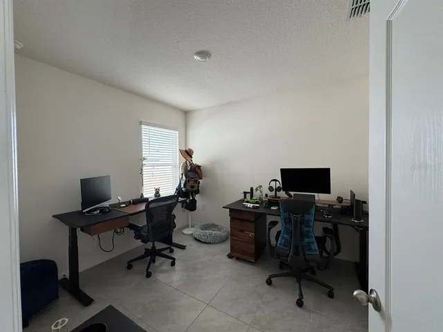 a view of a workspace with furniture and a window
