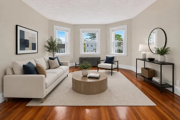 a living room with furniture and a wooden floor