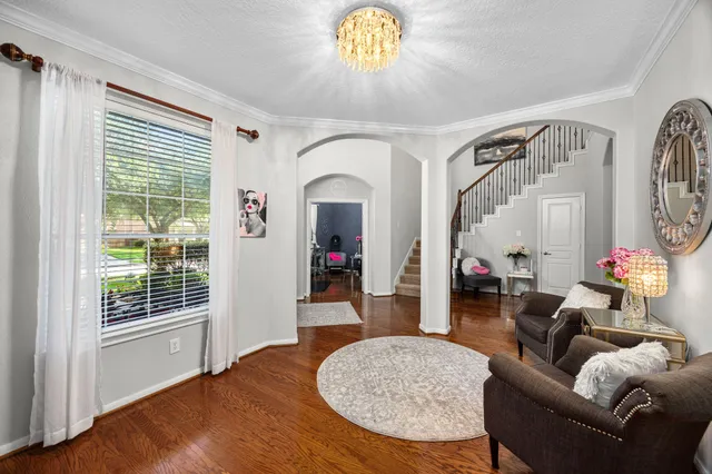 a living room with furniture a chandelier and a window