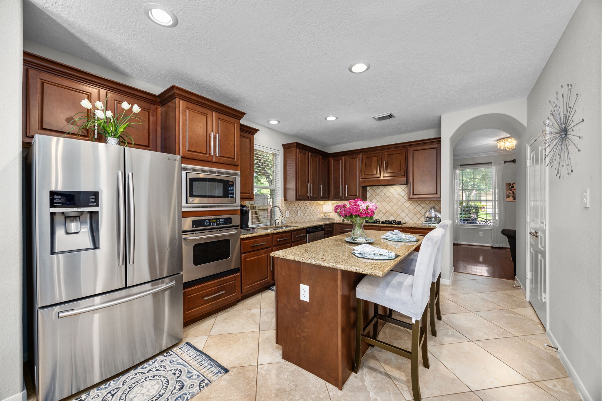 4402 Eden Point Lane Katy, TX 77494 - Photo 15 of 43 a kitchen with stainless steel appliances kitchen island granite countertop a refrigerator a stove a sink a dining table and chairs with wooden floor