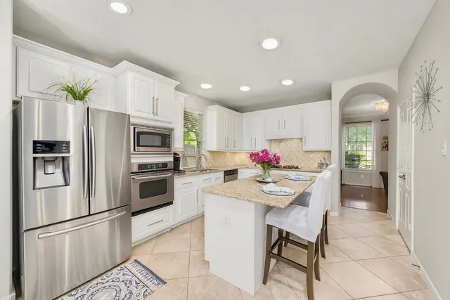 a kitchen with white cabinets and stainless steel appliances