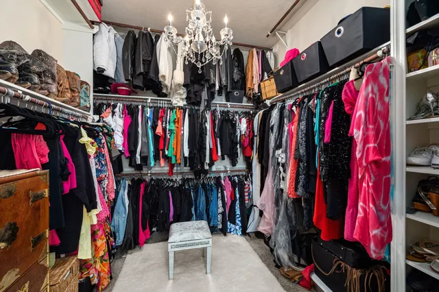 a view of walk in closet with clothes