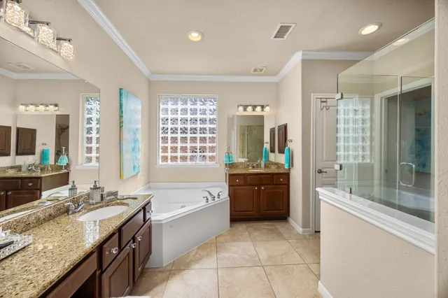 a large spacious bathroom with a granite countertop tub sink shower and mirror