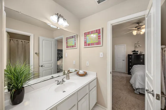 a en suite bathroom with a sink double vanity granite and a mirror