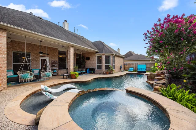 swimming pool view with a seating space and a garden view