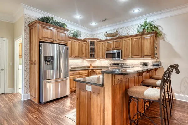 a kitchen with granite countertop a refrigerator stove and sink