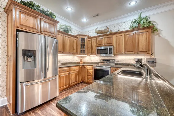 a kitchen with stainless steel appliances granite countertop a refrigerator and a sink