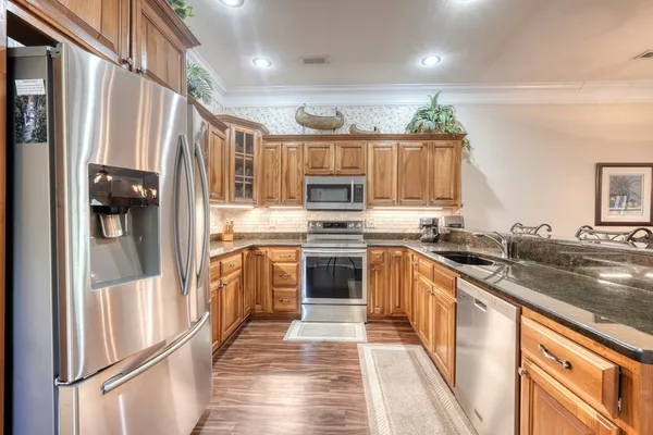 a kitchen with granite countertop a stove top oven and sink