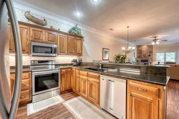 a kitchen with stainless steel appliances granite countertop a refrigerator a sink and a stove