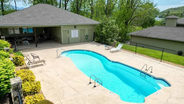 a view of a house with pool and chairs