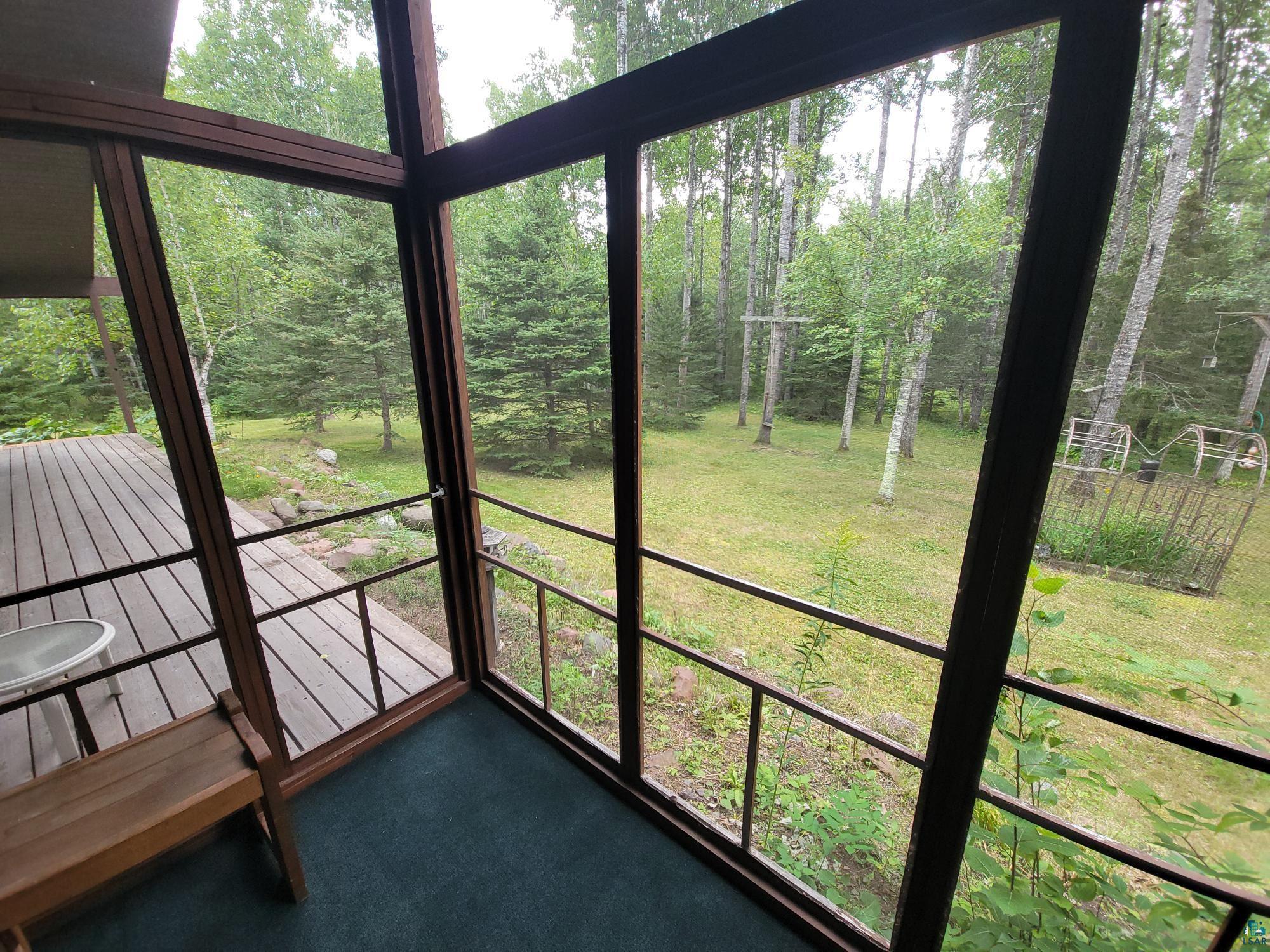181 Linnell Road Grand Marais, MN 55604 - Photo 17 of 77 Screened porch with carpet flooring and direct access to an exterior wood-decked patio