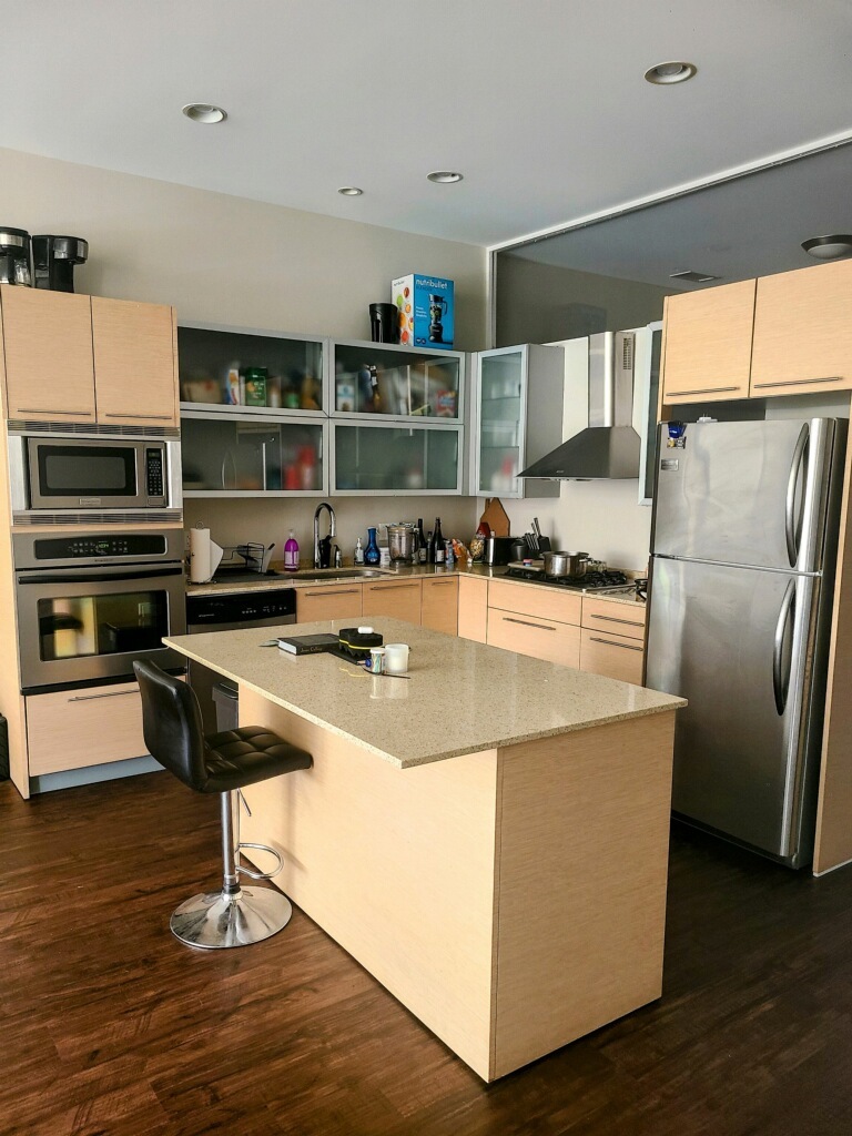 1222 West Madison Street, Unit 501 Chicago, IL 60607 - Photo 3 of 24 a kitchen with kitchen island a counter top a sink a stove and a refrigerator