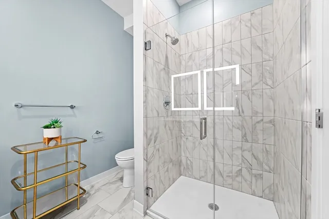 a bathroom with a sink toilet a mirror and shower