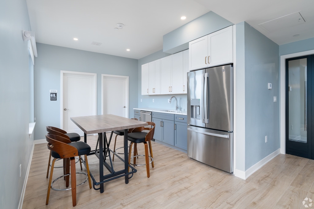 500 Talbot Avenue, Unit 308 Boston, MA 02124 - Photo 15 of 22 a kitchen with stainless steel appliances a refrigerator a stove a dining table and chairs