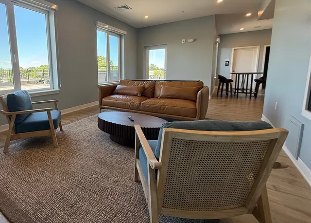 a view of a rooftop deck with couch and chairs