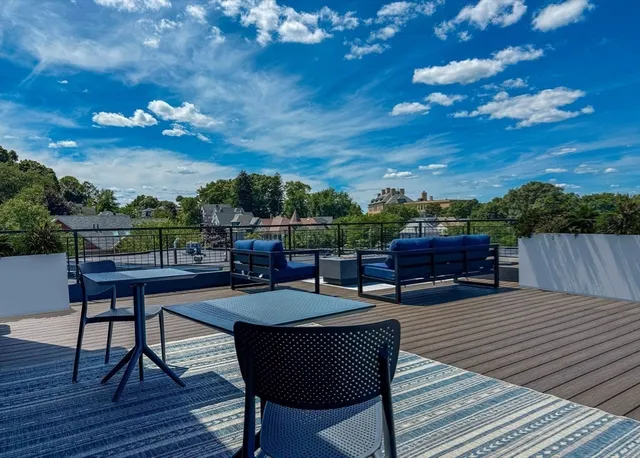 a view of a patio with couches and potted plants with sky view