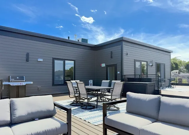 a view of a roof deck with couches and wooden floor