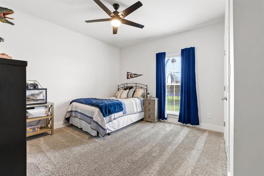 112 Chisolm Trail Pottsboro, TX 75076 - Photo 17 of 40 a bedroom with a bed and a chandelier