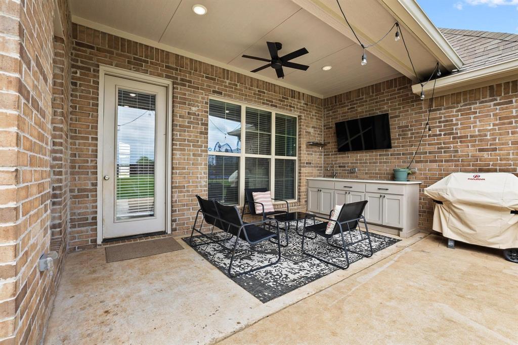 112 Chisolm Trail Pottsboro, TX 75076 - Photo 31 of 40 a living room with furniture a flat screen tv and a fireplace