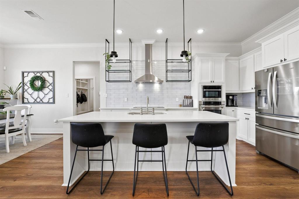 112 Chisolm Trail Pottsboro, TX 75076 - Photo 6 of 40 a kitchen with stainless steel appliances kitchen island a table and chairs in it