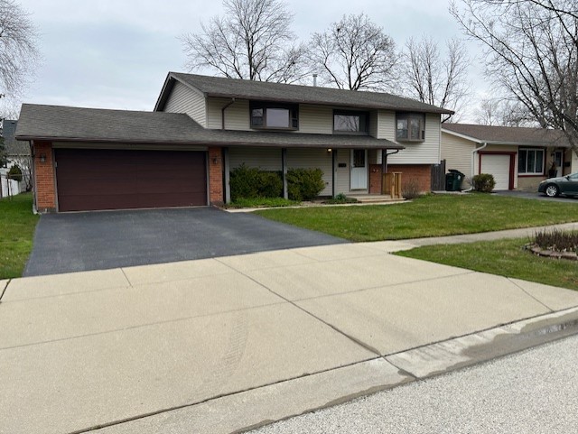 546 Yarmouth Road Elk Grove Village, IL 60007 - Photo 1 of 18 a front view of a house with a yard and garage