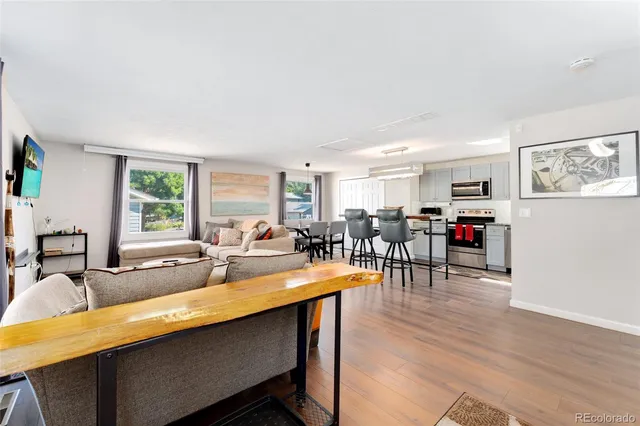 a living room with furniture a dining table and wooden floor