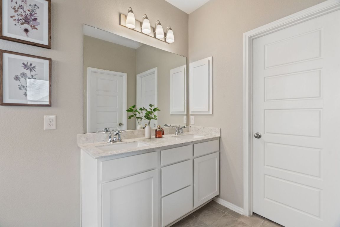 7504 Groundhog Way Austin, TX 78744 - Photo 12 of 22 The primary bathroom features dual vanities and a separate water closet for extra privacy.