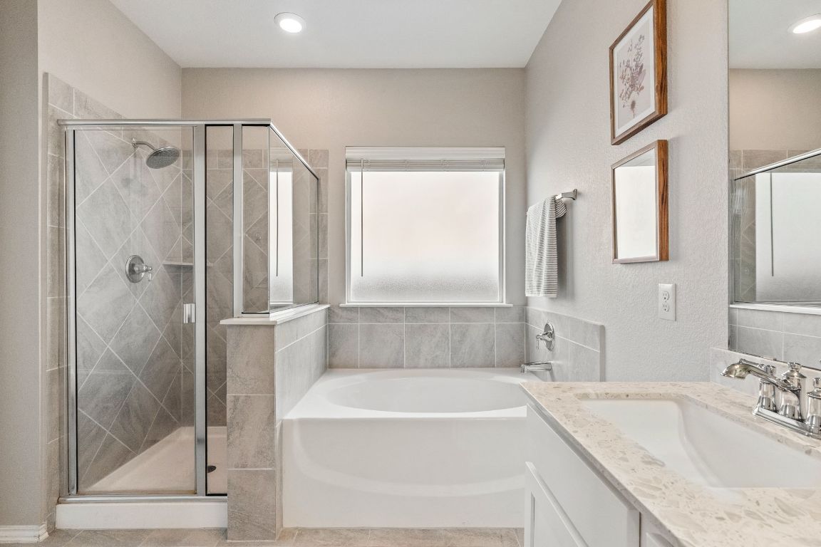 7504 Groundhog Way Austin, TX 78744 - Photo 13 of 22 Relax in the large soaking tub or the sparkling shower in the primary bathroom.