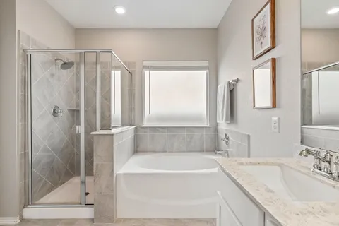 a bathroom with a tub a sink and a mirror