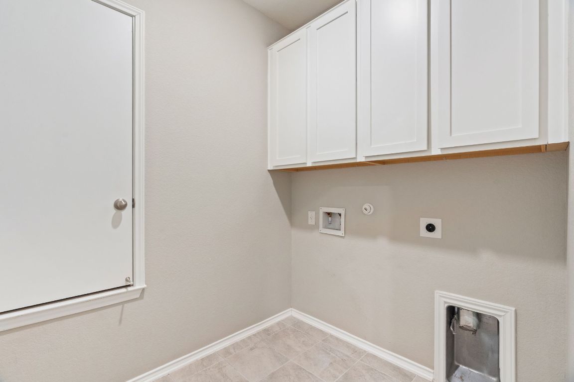 7504 Groundhog Way Austin, TX 78744 - Photo 19 of 22 The convenient laundry room features extra storage.