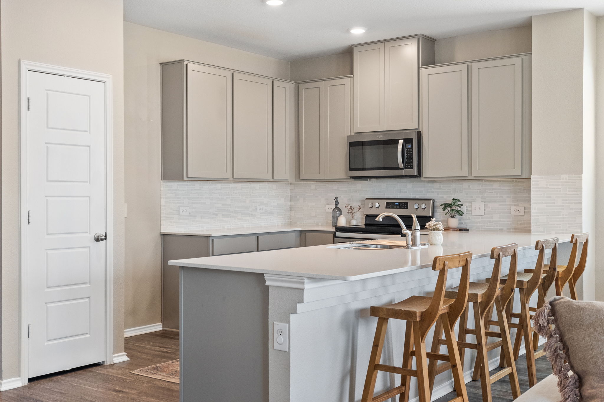 7504 Groundhog Way Austin, TX 78744 - Photo 3 of 22 a kitchen with stainless steel appliances granite countertop a stove a sink a microwave and a refrigerator
