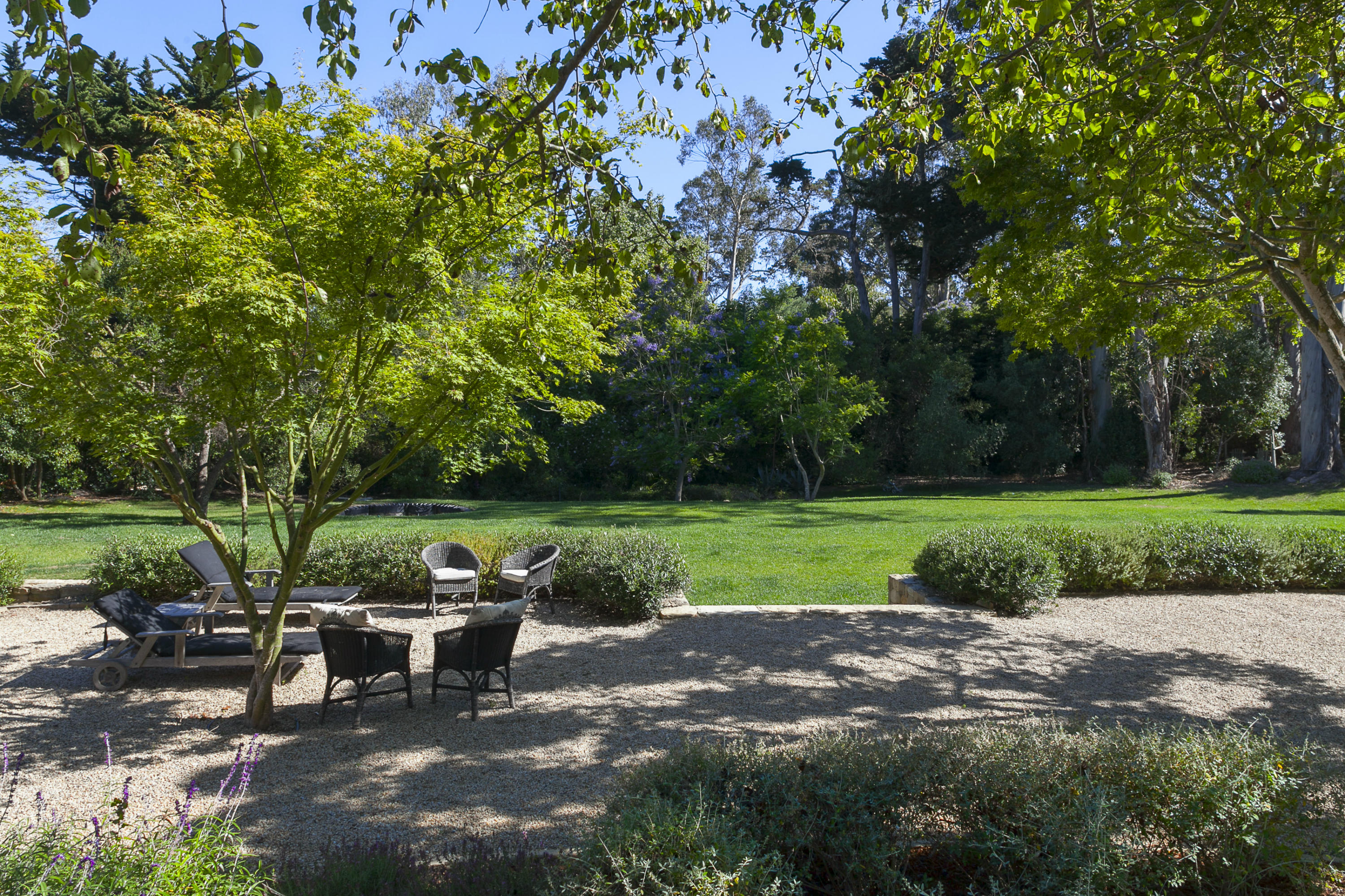 1381 East Valley Road Montecito, CA 93108 - Photo 11 of 13 a view of a patio with table and chairs potted plants and a large tree