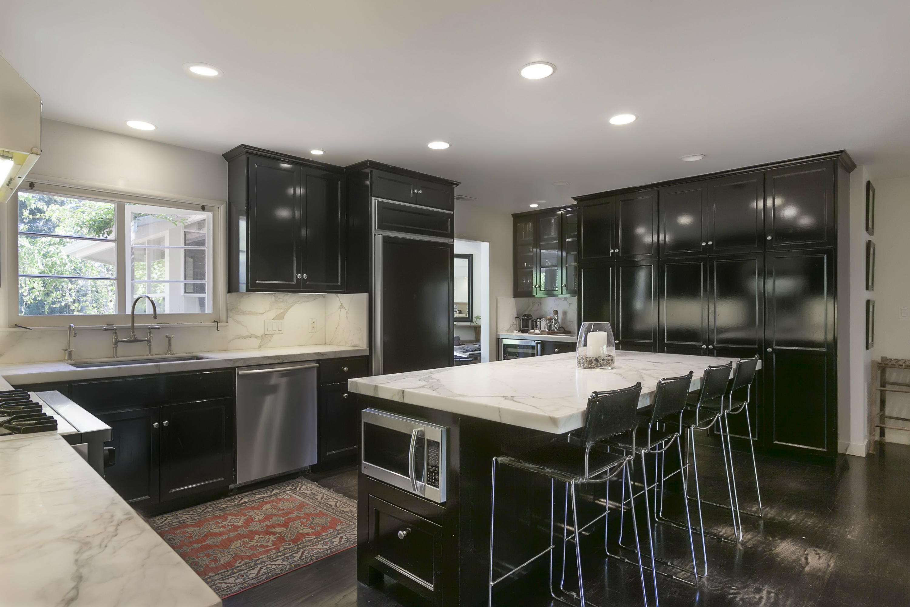 1381 East Valley Road Montecito, CA 93108 - Photo 8 of 13 a kitchen with stainless steel appliances granite countertop a sink table and chairs