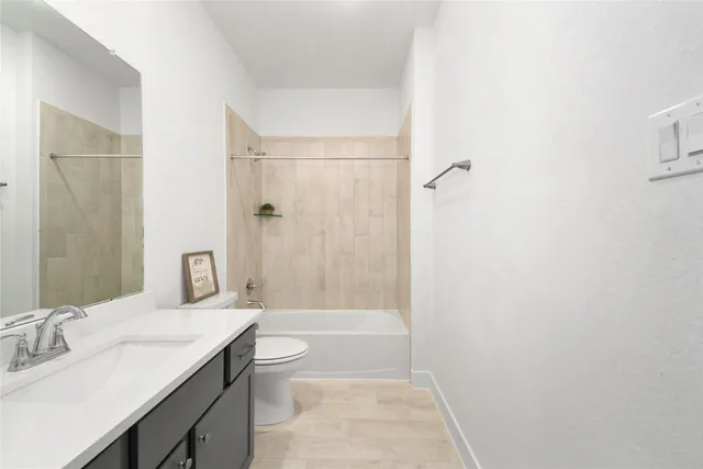 a bathroom with a granite countertop sink a toilet and shower