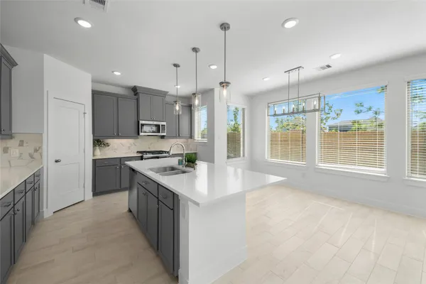 a kitchen with kitchen island a sink stainless steel appliances and window