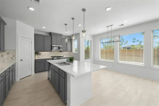a kitchen with kitchen island a sink stainless steel appliances and window