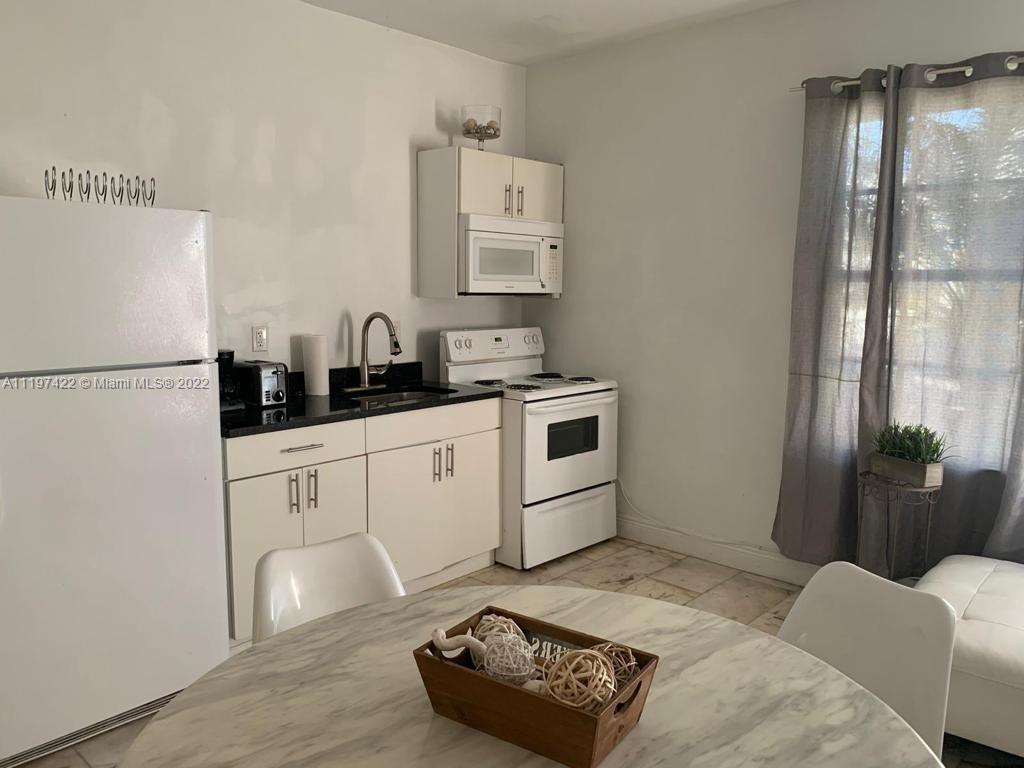 Flamingo-Lummus Miami Beach, FL 33139 - Photo 3 of 8 a kitchen with stainless steel appliances granite countertop a refrigerator sink and white cabinets