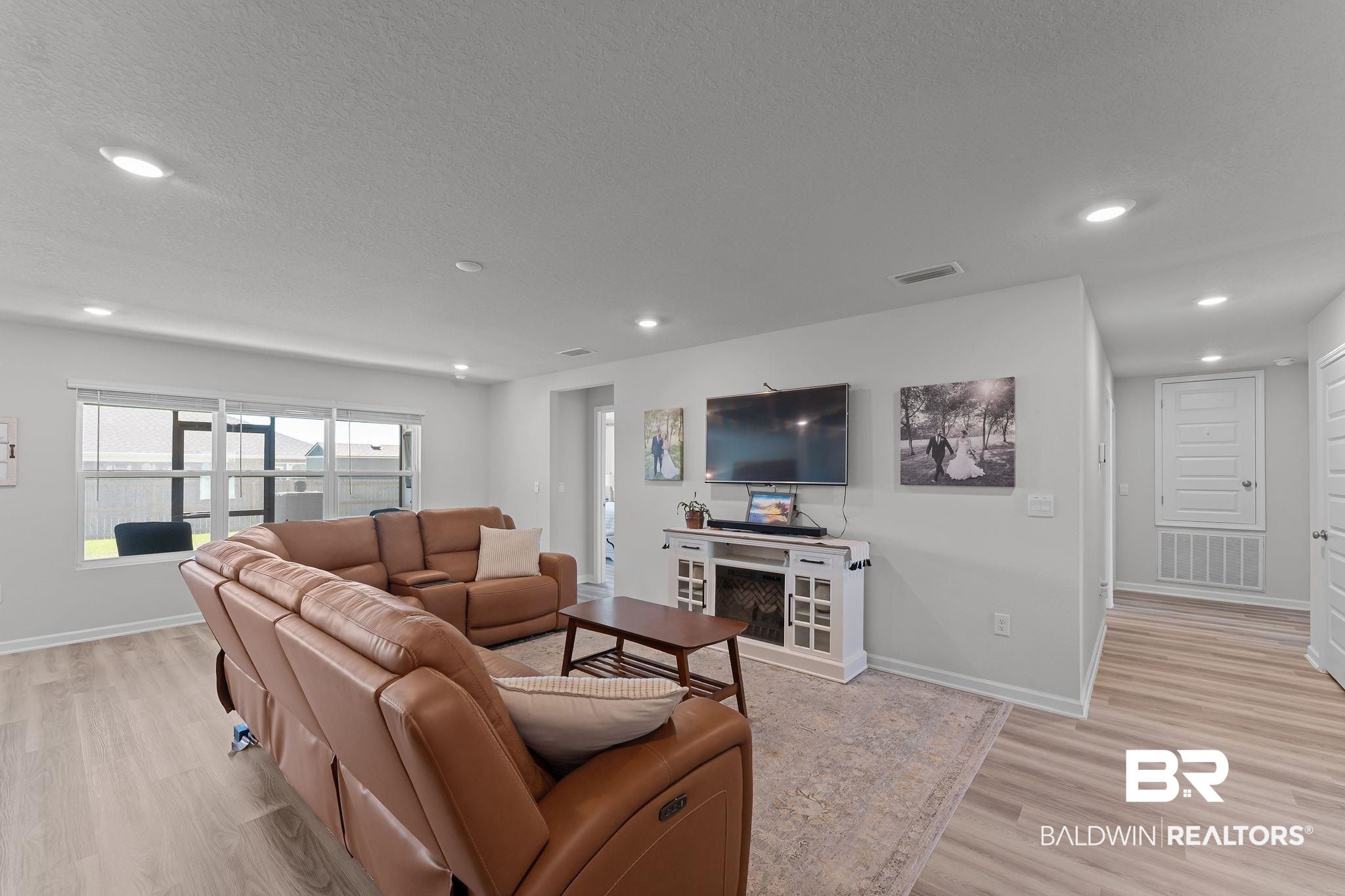 24337 Ringneck Loop Elberta, AL 36530 - Photo 6 of 34 Living room featuring light wood-type flooring, recessed lighting, and a textured ceiling