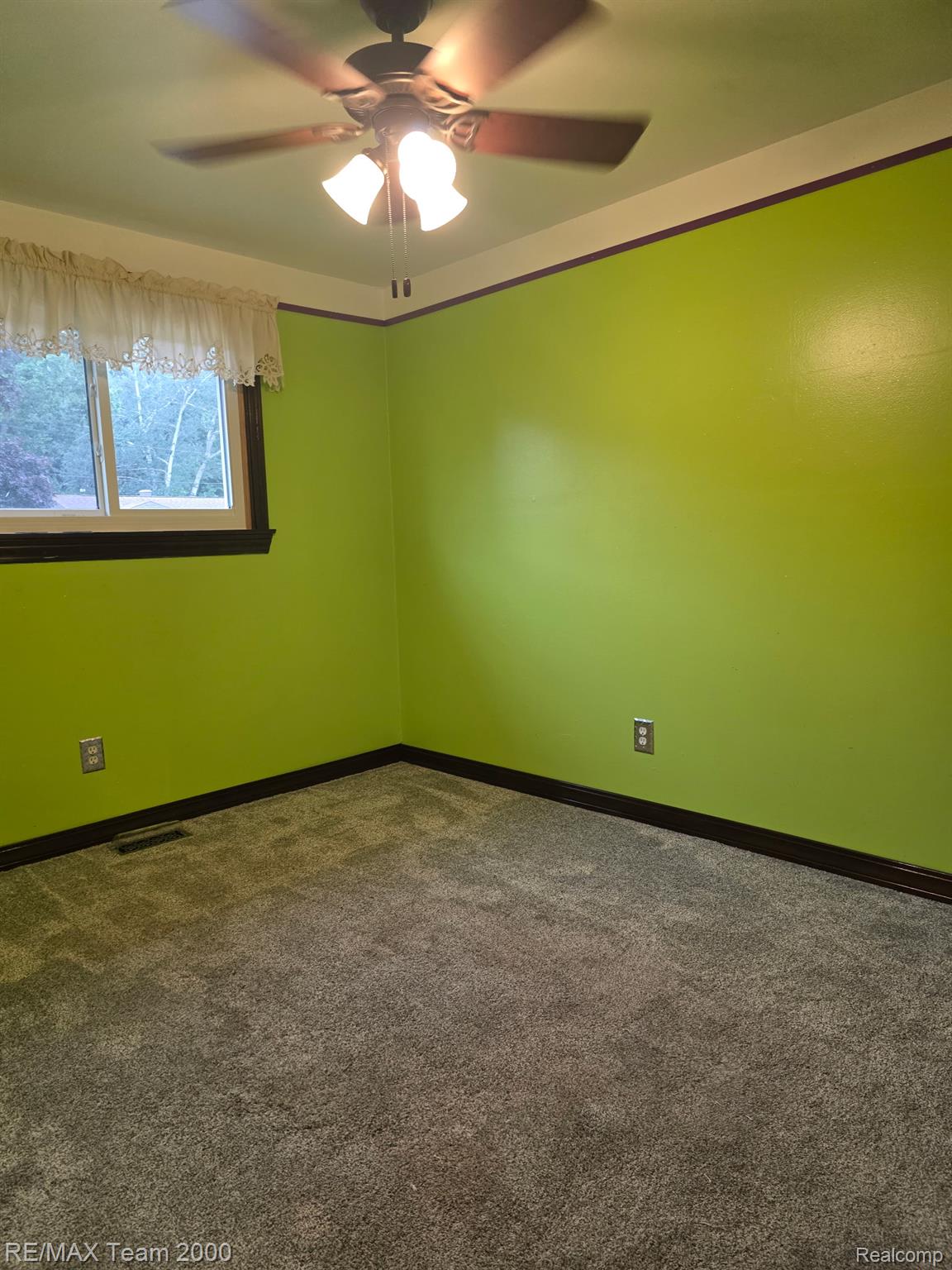 38114 Walnut Street Romulus, MI 48174 - Photo 9 of 18 Room with bright green walls, dark wood-finish trim, and gray carpet